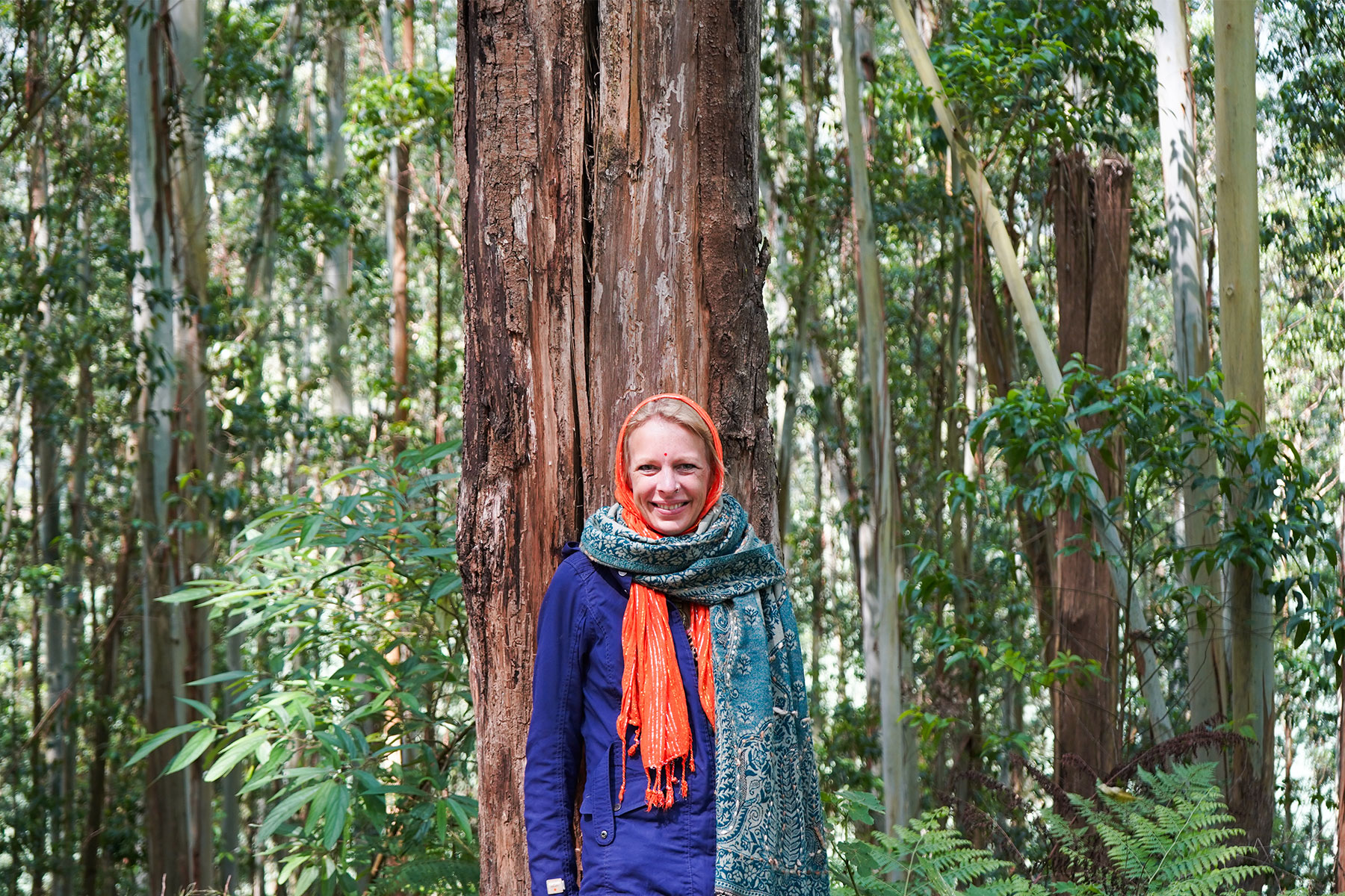 Eco-point-lady-standing-infront-of-tree-munnar-kerala-india-firstman.earth